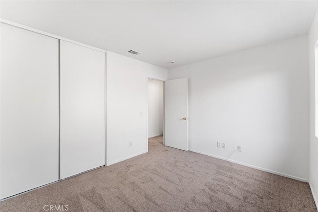 unfurnished bedroom featuring a closet, visible vents, and carpet