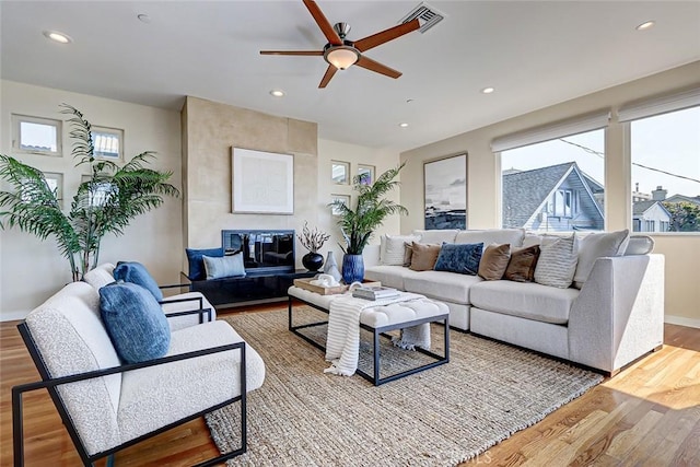 living room with wood-type flooring and ceiling fan