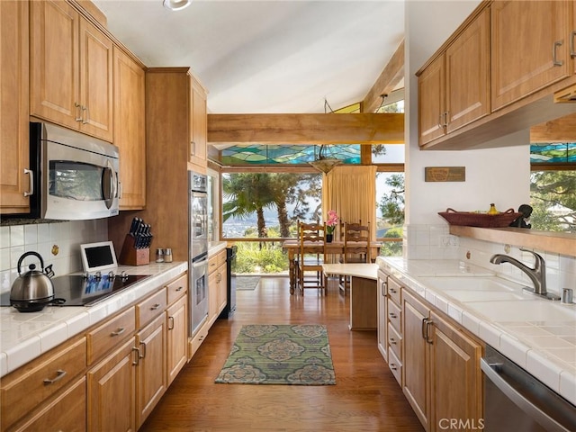 kitchen featuring appliances with stainless steel finishes, tile countertops, sink, decorative backsplash, and plenty of natural light