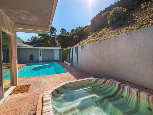 view of pool with a patio and an in ground hot tub