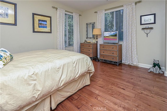 bedroom featuring dark wood-style flooring and baseboards