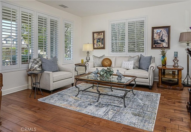 living area with visible vents, dark wood finished floors, and baseboards