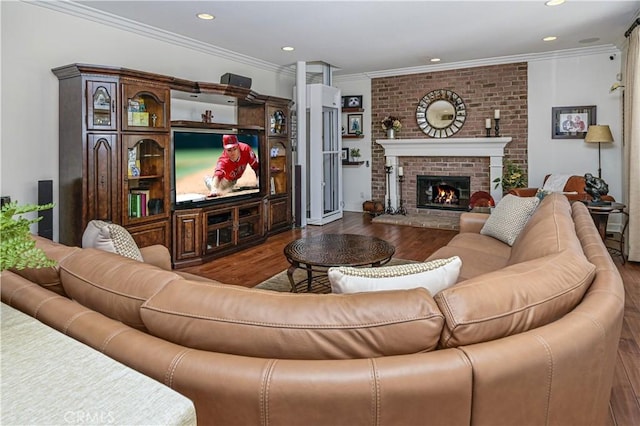 living area featuring ornamental molding, recessed lighting, a brick fireplace, and wood finished floors