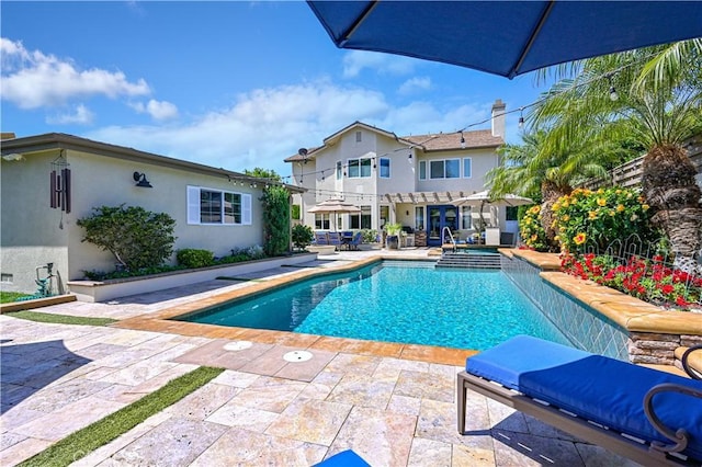 view of pool with a patio area and a pool with connected hot tub