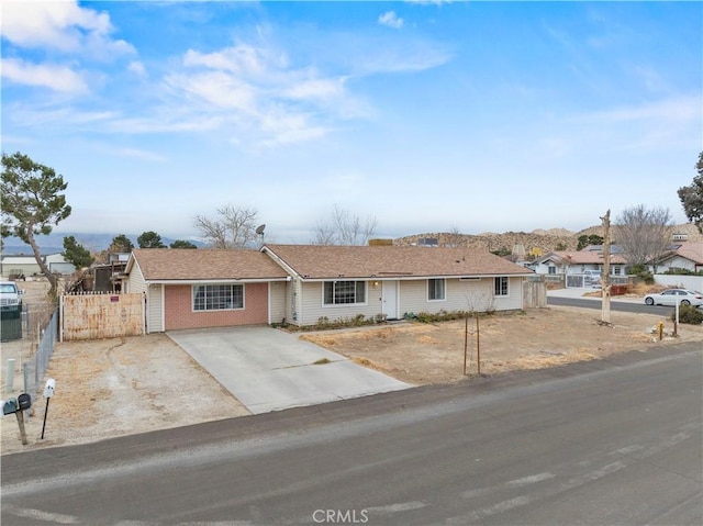 ranch-style house featuring brick siding and fence