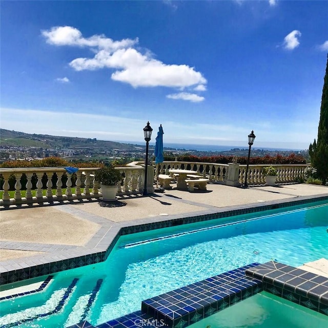 view of swimming pool featuring a patio and a pool with connected hot tub