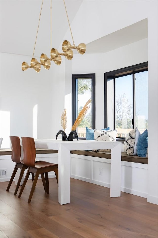 dining space featuring dark wood-type flooring and vaulted ceiling