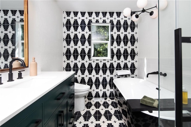 bathroom with tile patterned floors, toilet, tile walls, vanity, and a bathtub