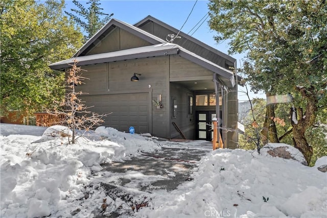 view of snowy exterior featuring a garage