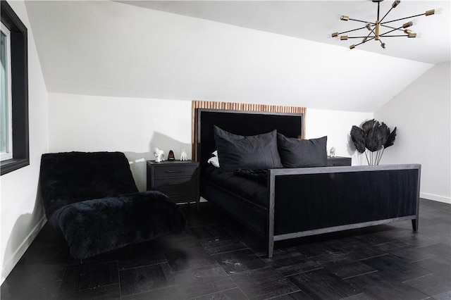 bedroom with lofted ceiling and a notable chandelier