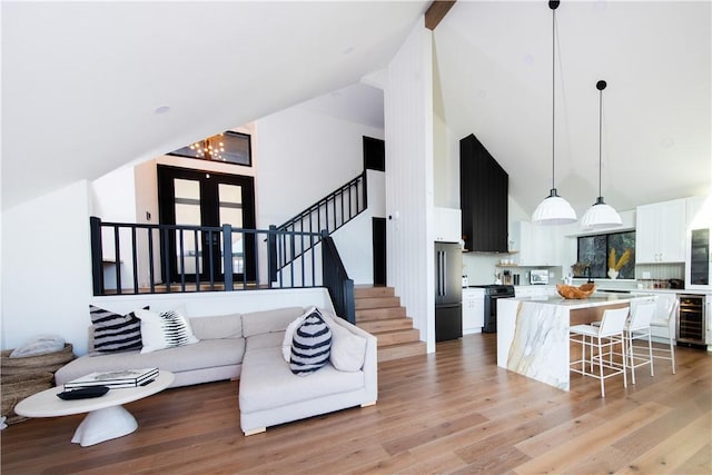 living room featuring wine cooler, high vaulted ceiling, and light hardwood / wood-style floors