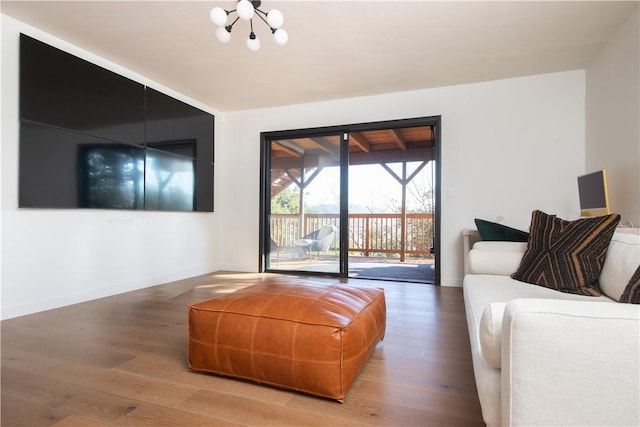 living room featuring wood-type flooring and an inviting chandelier