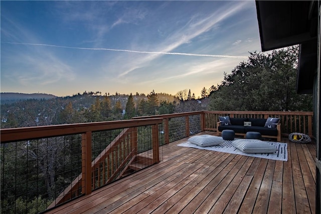 deck at dusk featuring an outdoor hangout area