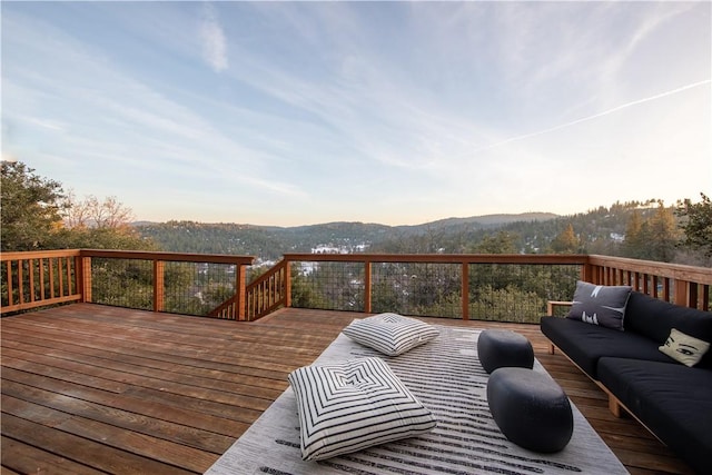 deck at dusk featuring an outdoor living space and a mountain view