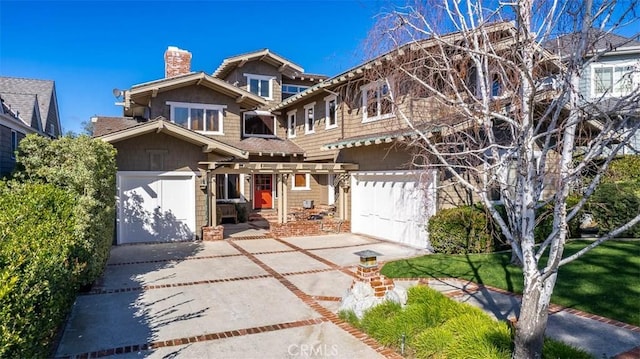 view of front of property with a garage, driveway, and a chimney