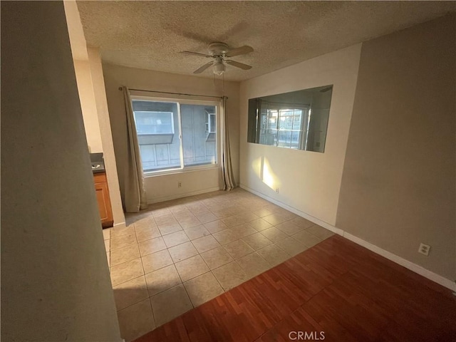 unfurnished room with ceiling fan, a textured ceiling, and light tile patterned floors