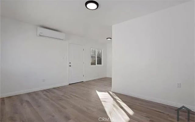 empty room with hardwood / wood-style floors and a wall unit AC