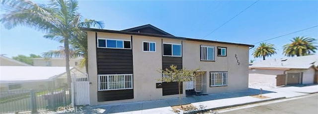 view of front facade featuring fence and stucco siding