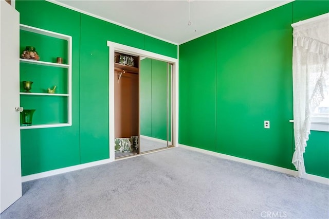 unfurnished bedroom with ornamental molding, carpet floors, and a closet