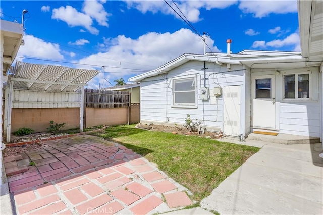 entrance to property with a yard and a patio area