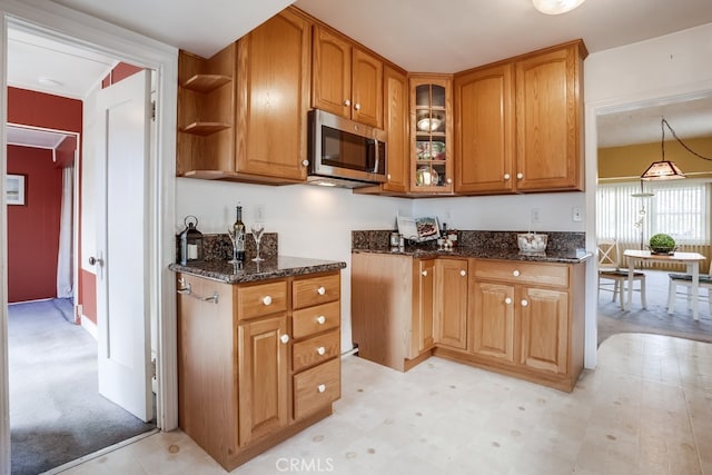 kitchen featuring decorative light fixtures and dark stone counters