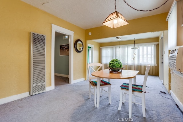 dining space featuring light colored carpet and a textured ceiling