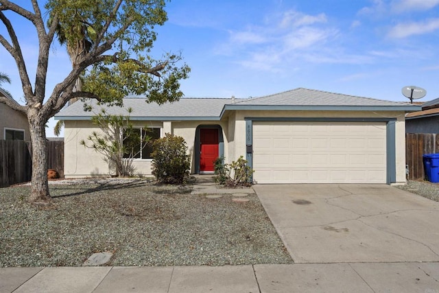 single story home with a garage, concrete driveway, fence, and stucco siding