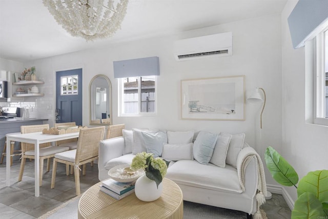 living room featuring an inviting chandelier, plenty of natural light, and a wall mounted AC