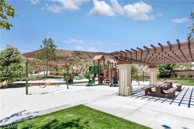 view of community with a mountain view, volleyball court, and a playground