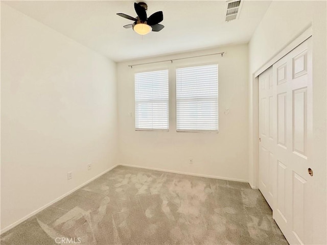 unfurnished bedroom with ceiling fan, a closet, and light carpet