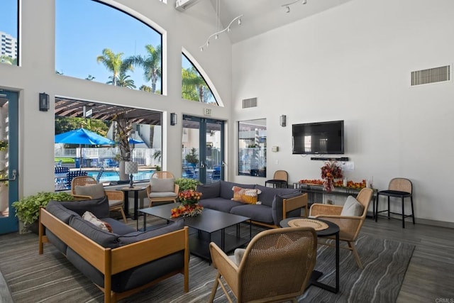 living room featuring french doors, dark hardwood / wood-style flooring, and a high ceiling