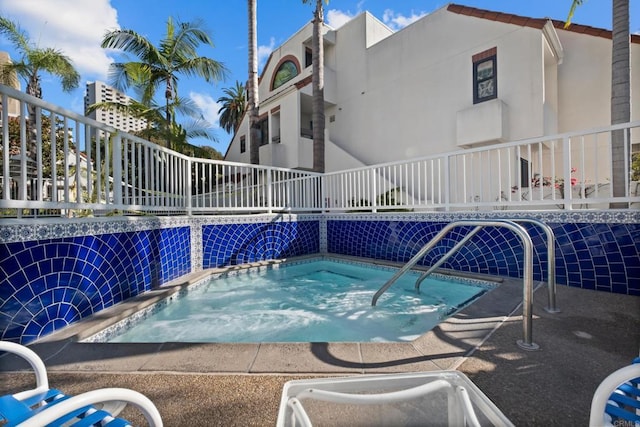 view of pool with a hot tub and pool water feature