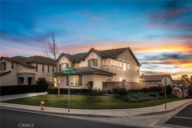 view of front of home featuring a front yard, a residential view, and stucco siding