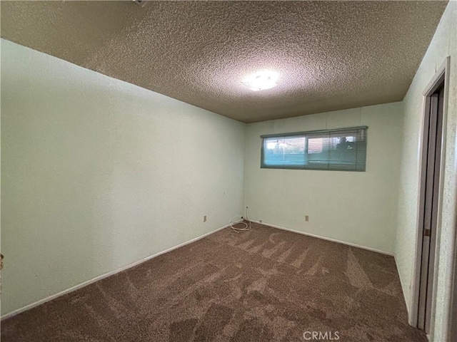 carpeted empty room with a textured ceiling