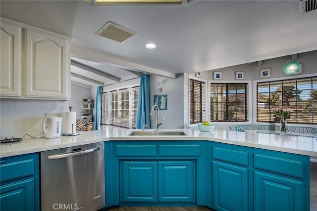 kitchen with vaulted ceiling with beams, dishwasher, blue cabinetry, sink, and white cabinetry