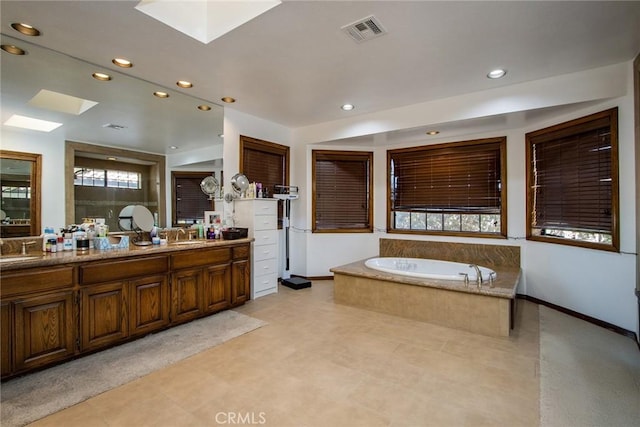 bathroom with vanity and a relaxing tiled tub