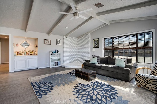 living room with wood-type flooring, vaulted ceiling with beams, indoor bar, a textured ceiling, and ceiling fan