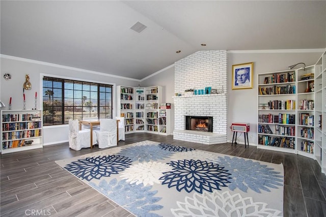 living area with a fireplace, vaulted ceiling, and crown molding