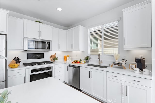 kitchen with sink, white cabinets, and appliances with stainless steel finishes