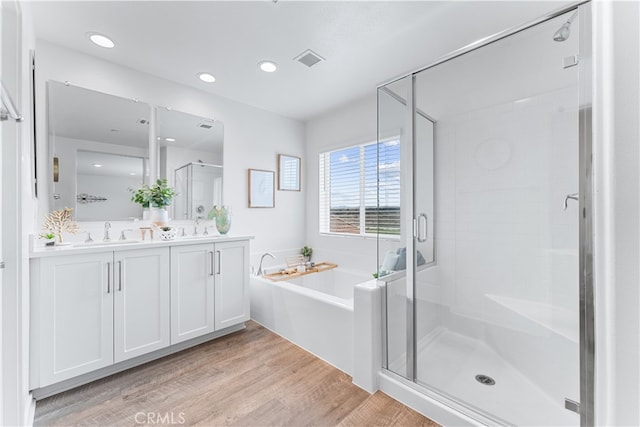 bathroom featuring vanity, hardwood / wood-style flooring, and shower with separate bathtub