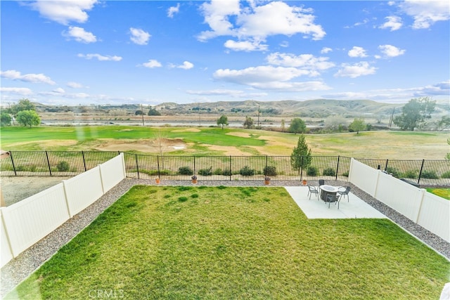 view of yard with a rural view, a mountain view, and a patio area