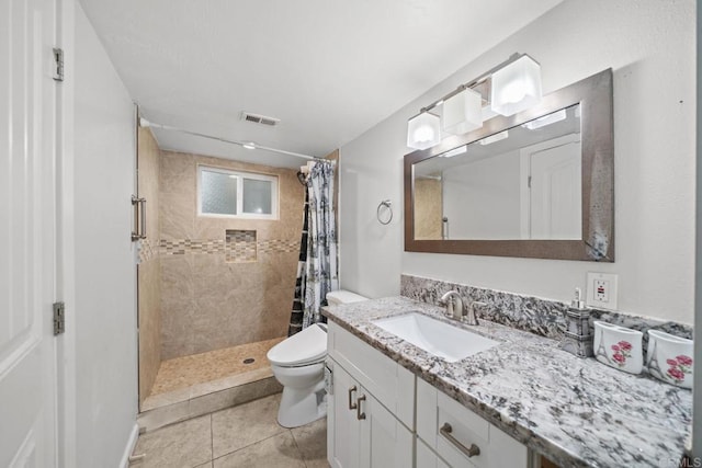 bathroom with tile patterned floors, vanity, toilet, and curtained shower