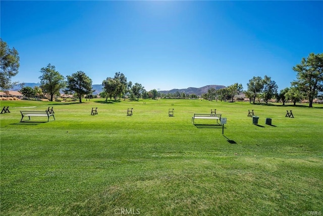 surrounding community with a mountain view and a lawn