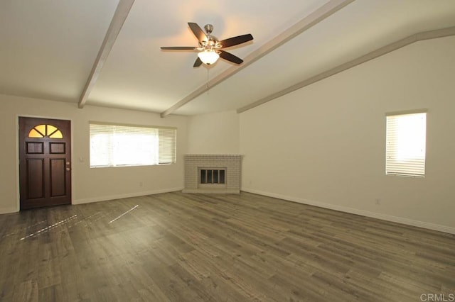 unfurnished living room featuring ceiling fan, dark hardwood / wood-style floors, lofted ceiling with beams, and a brick fireplace