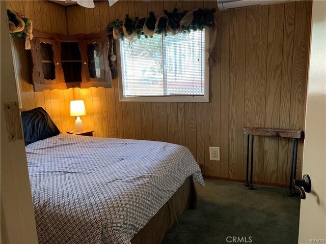 carpeted bedroom with wood walls