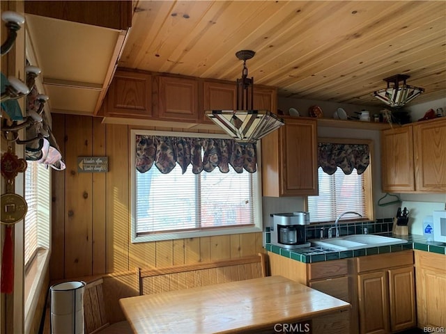 kitchen with wooden walls, sink, tile countertops, and wood ceiling