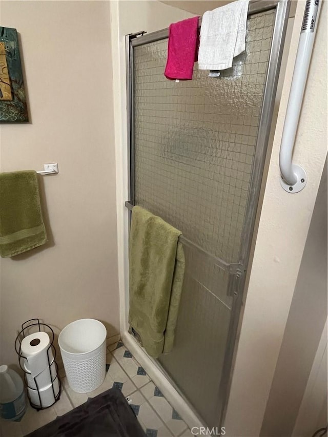 bathroom featuring a shower with door and tile patterned floors