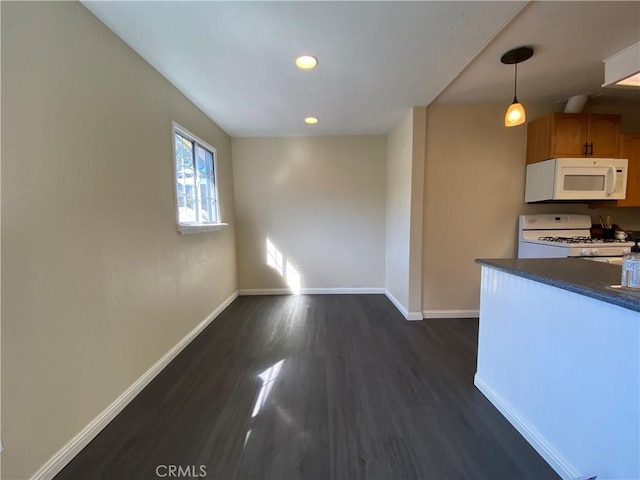 kitchen featuring dark hardwood / wood-style floors, white appliances, and decorative light fixtures