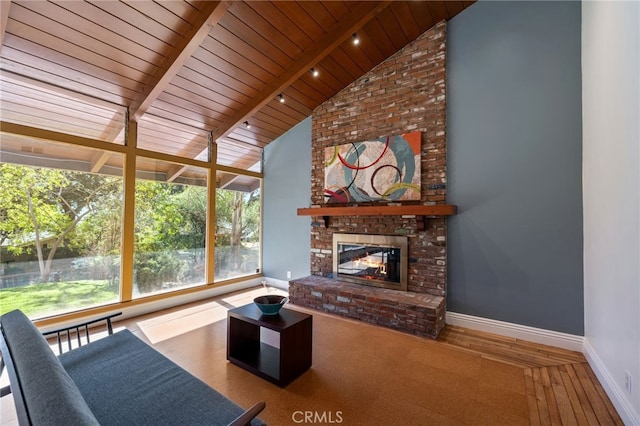 unfurnished sunroom with vaulted ceiling with beams, wood ceiling, and a fireplace