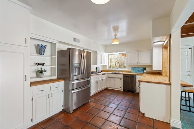 kitchen with sink, black dishwasher, stainless steel refrigerator with ice dispenser, pendant lighting, and white cabinets